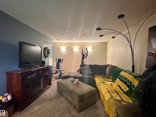 Carpeted room with recessed lighting and wall sconces - 10619 108 Avenue, Westlock, AB - Indoor