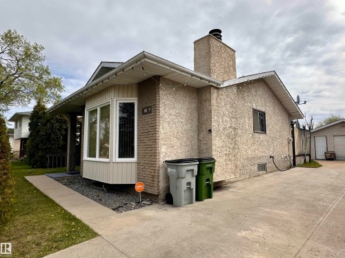 Exterior featuring a bay window, stucco siding, and a prominent chimney - 10619 108 Avenue, Westlock, AB - Outdoor With Exterior