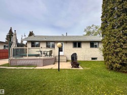 Rear exterior with textured stucco finish and a shingle roof - 