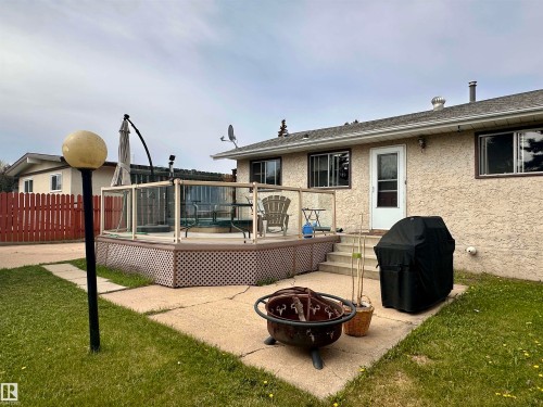Expansive rear deck with glass panel railing and lattice skirting - 10619 108 Avenue, Westlock, AB - Outdoor With Deck Patio Veranda With Exterior