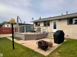 Expansive rear deck with glass panel railing and lattice skirting - 