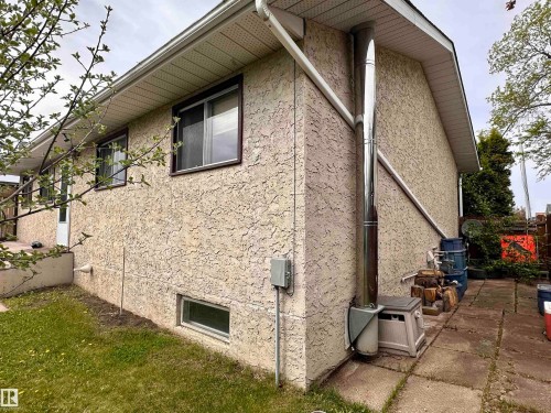 Stucco exterior featuring multiple windows and a lower-level window - 10619 108 Avenue, Westlock, AB - Outdoor With Exterior