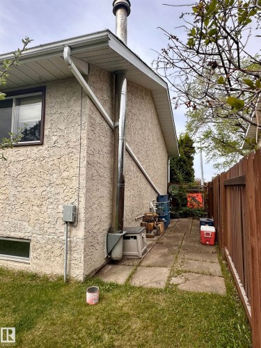 Light stucco exterior with a prominent metal chimney - 10619 108 Avenue, Westlock, AB - Outdoor With Exterior