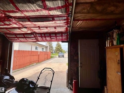 Attached garage with an insulated overhead door, a pedestrian access door, and a partially finished interior - 10619 108 Avenue, Westlock, AB - Indoor
