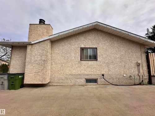 Exterior stucco finish with a prominent chimney structure and a peaked roofline - 10619 108 Avenue, Westlock, AB - Outdoor With Exterior