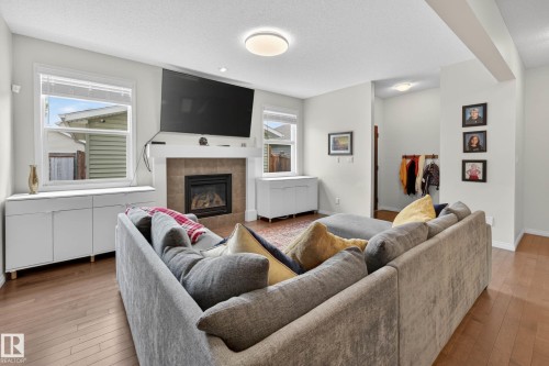 Living area featuring wood-finish flooring and light-toned walls - 2007 72 Street, Edmonton, AB - Indoor Photo Showing Living Room With Fireplace
