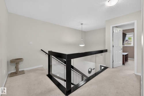 Contemporary glass and dark wood railing, neutral wall color, recessed lighting, and carpeted flooring - 2007 72 Street, Edmonton, AB - Indoor Photo Showing Other Room