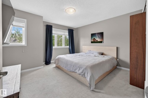 Carpeted bedroom featuring neutral wall paint, white baseboards, and a contemporary ceiling light fixture - 2007 72 Street, Edmonton, AB - Indoor Photo Showing Bedroom