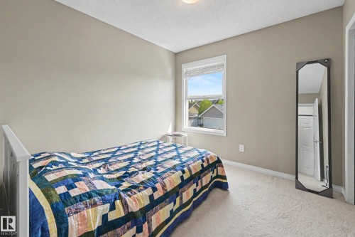 Neutral tone wall paint, light-colored carpeting, white trim, a single window with blinds, and an overhead light fixture - 2007 72 Street, Edmonton, AB - Indoor Photo Showing Bedroom