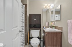 Bathroom featuring a wood-finish vanity with an integrated sink and backsplash, a three-light vanity fixture, and a wall-mounted medicine cabinet - 