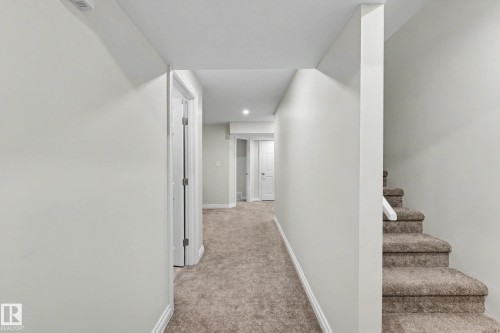 Carpeted hallway featuring white trim and matching interior doors - 2007 72 Street, Edmonton, AB - Indoor Photo Showing Other Room