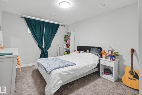 Carpeted room featuring light gray walls and a white ceiling with a flush-mount light fixture - 2007 72 Street, Edmonton, AB - Indoor Photo Showing Bedroom
