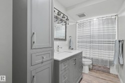 Contemporary bathroom featuring a gray shaker-style vanity with a white countertop and undermount sink - 
