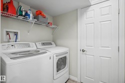 Dedicated laundry area featuring a washer and dryer, an overhead wire shelving unit, and a six-panel interior door - 