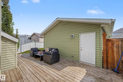 Expansive wood deck with a detached accessory structure, light green horizontal siding, and a white exterior door - 2007 72 Street, Edmonton, AB - Outdoor With Deck Patio Veranda With Exterior
