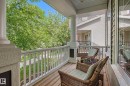 Covered front porch with wood-finish flooring, white spindle railing, and architectural columns - 2007 72 Street, Edmonton, AB  - Outdoor With Deck Patio Veranda With Exterior 