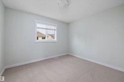 Light-filled room featuring neutral wall paint, textured ceiling, and a single window with white trim and blinds - 
