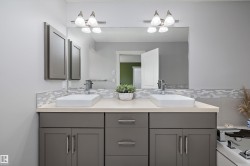 Dual vessel sinks set atop a light-toned countertop, complemented by a mosaic tile backsplash - 