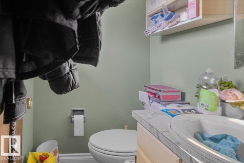 Bathroom vanity with an integrated sink, laminate countertop, and light-toned cabinetry - 13224 37 Street, Edmonton, AB 