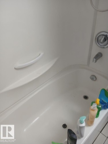 White acrylic bathtub with integrated grab bar and chrome fixtures - 13224 37 Street, Edmonton, AB 