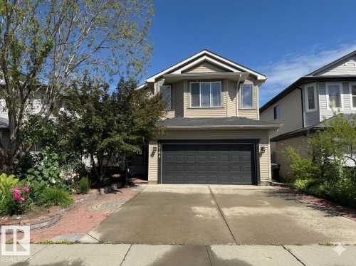 Two-story residence featuring light beige siding and a dark shingled roof - 1764 Melrose Crescent, Edmonton, AB 
