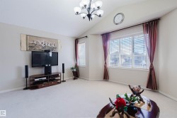 Living area featuring a vaulted ceiling and a chandelier - 