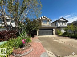 Two-story residence featuring a neutral exterior, attached garage, and a concrete driveway - 