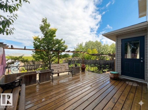 Expansive wood deck with pergola framework and a wrought iron railing - 1764 Melrose Crescent, Edmonton, AB 