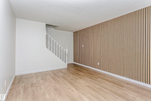 Open concept living area featuring a modern wood slat accent wall - 5418 144B Avenue, Edmonton, AB 