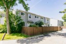 Two-story townhome with light gray siding, white trim, and a fenced private yard - 5418 144B Avenue, Edmonton, AB 