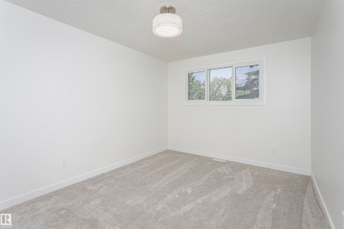 Light gray wall-to-wall carpeting complements the white walls and trim - 5418 144B Avenue, Edmonton, AB 