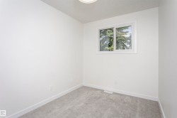 Room featuring light gray carpeting, crisp white walls, white baseboards, and a white-framed window - 