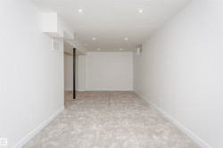 Spacious room featuring new light-toned carpeting, recessed ceiling lighting, crisp white walls, and contemporary white baseboards - 