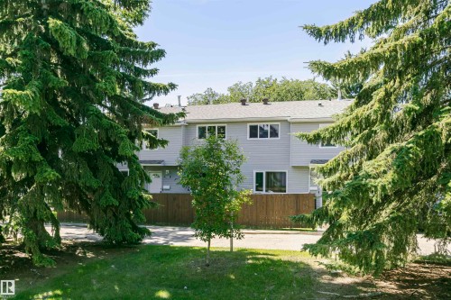 Contemporary townhouse exterior featuring light grey siding and a dark roof - 5418 144B Avenue, Edmonton, AB 