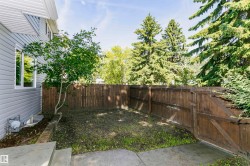 Fenced yard space featuring a mature privacy fence, concrete patio, and garden bed with established greenery - 
