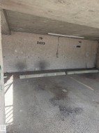 Designated parking space featuring a concrete wall with unit numbers - 