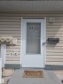 Entryway featuring a storm door with numerical addressing, an exterior wall light, and a black mailbox - 8433 29 Avenue, Edmonton, AB  - Outdoor With Exterior 