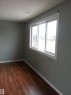 Room featuring wood-finish flooring, light gray walls, a white trim package, and a multi-pane window - 8433 29 Avenue, Edmonton, AB  - Indoor Photo Showing Other Room 