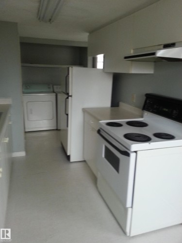 Kitchen featuring white appliances, including a refrigerator and electric range, with white cabinetry and countertops - 8433 29 Avenue, Edmonton, AB - Indoor Photo Showing Kitchen