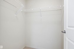 Walk-in closet featuring wire shelving, integrated hanging rods, and light-toned wall paint - 