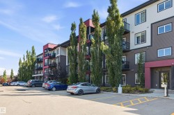 Contemporary multi-story building featuring dark siding, white trim, and red architectural accents - 