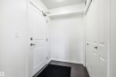 Entryway featuring dark wood-finish flooring, white walls, and a white paneled door with brushed nickel hardware - 435 5515 7 Avenue, Edmonton, AB 