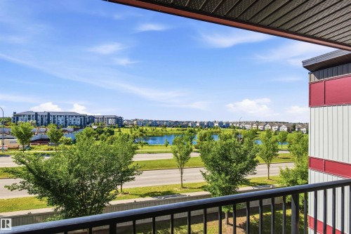 Balcony with black metal railing, offering expansive landscape and water feature - 435 5515 7 Avenue, Edmonton, AB 