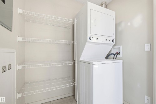 Dedicated laundry area featuring a white Frigidaire stacked washer and dryer unit - 435 5515 7 Avenue, Edmonton, AB 