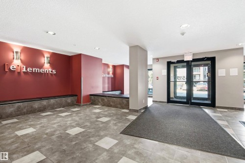 Building entry foyer featuring tile flooring, built-in benches, and modern wall sconces - 435 5515 7 Avenue, Edmonton, AB 