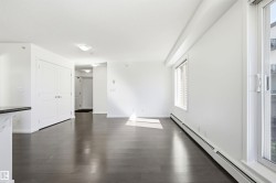 Bright living space featuring dark wood-finish flooring and white walls - 