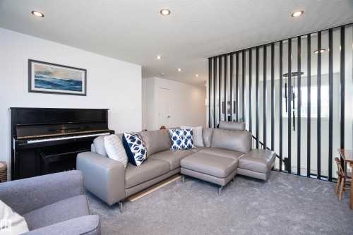 Recessed lighting illuminates this living space featuring light gray carpeting and white walls - 4714 Charles Bay Bay, Edmonton, AB 