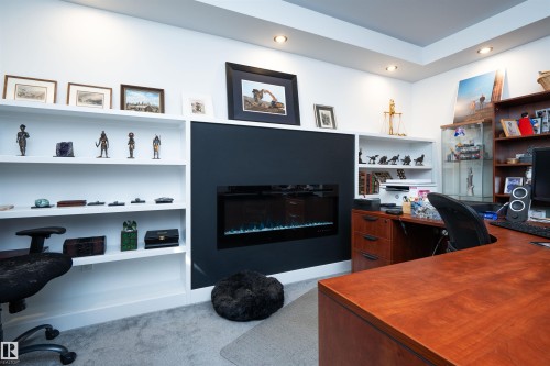 Integrated linear electric fireplace with a dark accent wall - 4714 Charles Bay Bay, Edmonton, AB 