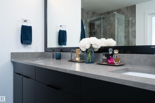 Spacious vanity featuring a light gray countertop, undermount sink, and dark cabinetry - 4714 Charles Bay Bay, Edmonton, AB 