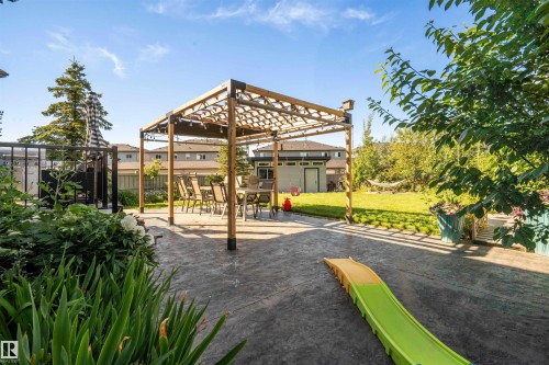 Expansive stamped concrete patio featuring a wood pergola - 4714 Charles Bay Bay, Edmonton, AB 